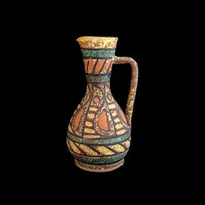 May include: A small, decorative ceramic pitcher with a yellow, orange, green, and brown geometric pattern.