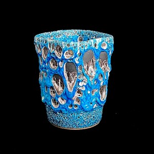 May include: A small, blue ceramic planter with a textured, bubbly surface. The planter has a dark blue and silver glaze.