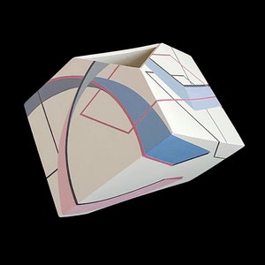 May include: A white ceramic vase with geometric shapes and abstract designs in shades of pink, blue, and gray.