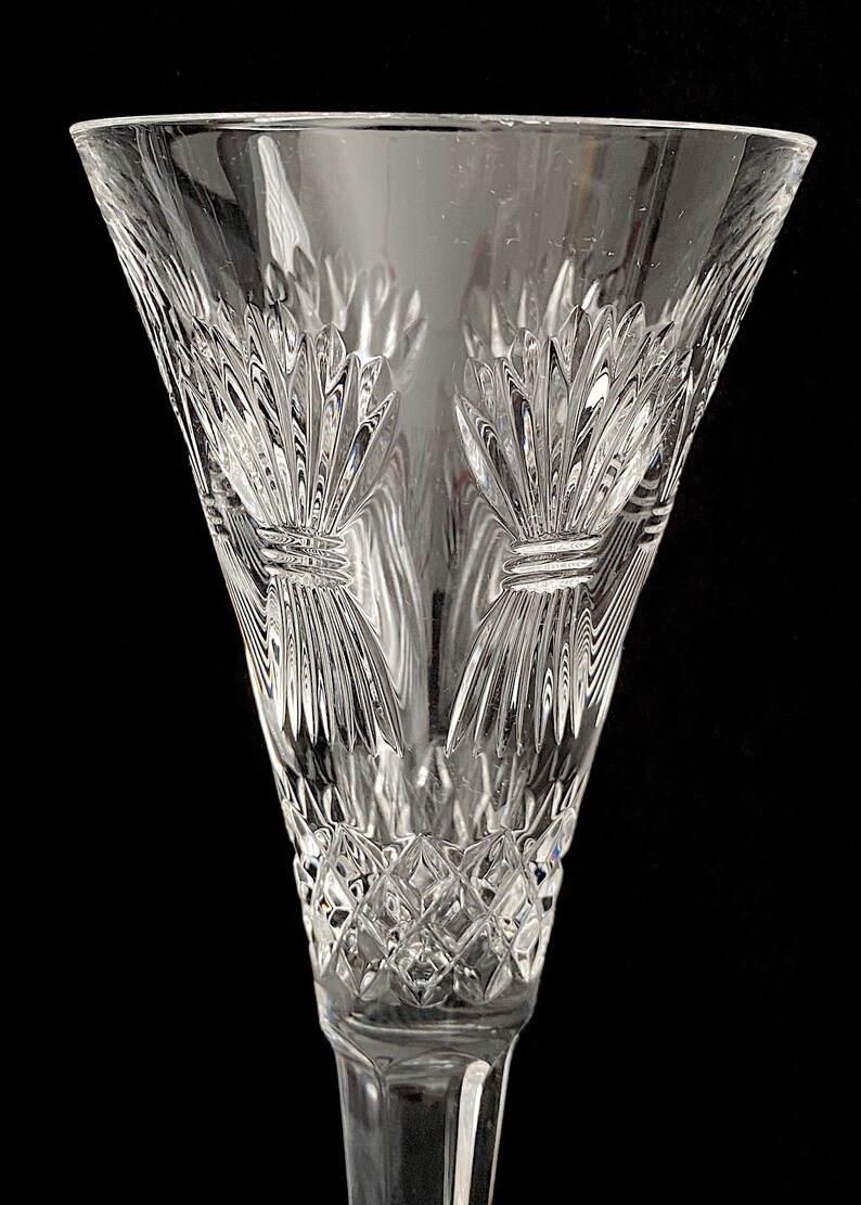K&ouml;nnte beinhalten: Eine klare Champagnerfl&ouml;te aus Glas mit einem geschliffenen Kristallmuster. Die Fl&ouml;te hat einen breiten Kelch und einen langen Stiel.