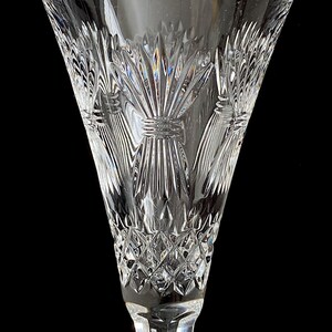 K&ouml;nnte beinhalten: Eine klare Champagnerfl&ouml;te aus Glas mit einem geschliffenen Kristallmuster, das ein Distelmotiv zeigt. Die Fl&ouml;te hat einen langen, schlanken Stiel.