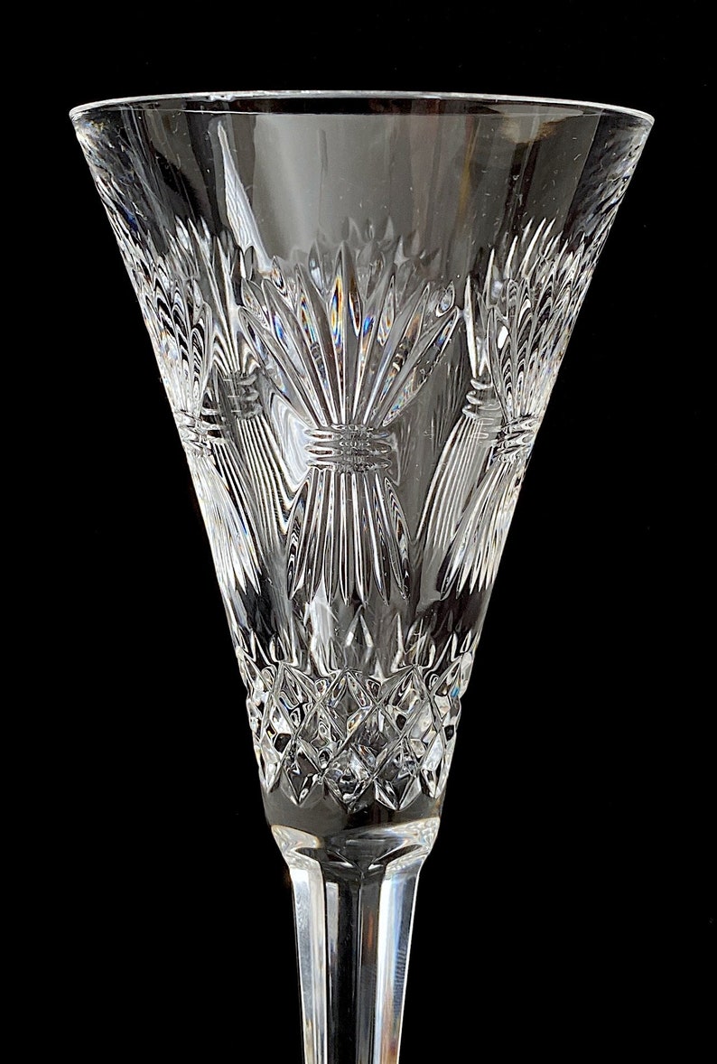 K&ouml;nnte beinhalten: Eine klare Champagnerfl&ouml;te aus Glas mit einem geschliffenen Kristallmuster, das ein Distelmotiv zeigt. Die Fl&ouml;te hat einen langen, schlanken Stiel.