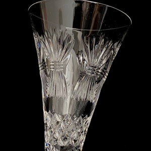 K&ouml;nnte beinhalten: Eine klare Champagnerfl&ouml;te aus Glas mit einem geschliffenen Kristallmuster. Die Fl&ouml;te hat einen breiten Kelch und einen langen Stiel.