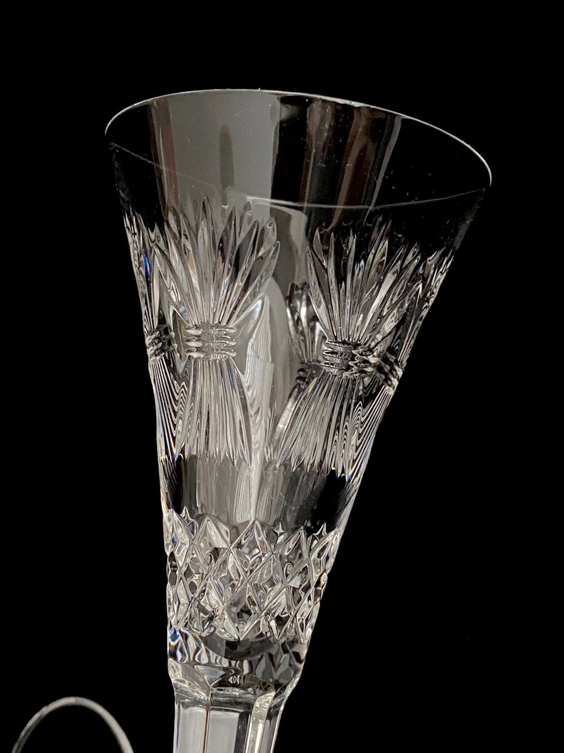 K&ouml;nnte beinhalten: Eine klare Champagnerfl&ouml;te aus Glas mit einem geschliffenen Kristallmuster. Die Fl&ouml;te hat einen breiten Kelch und einen langen Stiel.
