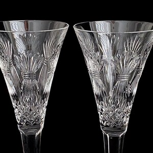 K&ouml;nnte beinhalten: Zwei klare Kristall-Champagnerfl&ouml;ten mit einem geschliffenen Glasdesign. Die Fl&ouml;ten haben einen hohen, schlanken Stiel und eine breite, schalenf&ouml;rmige Oberseite.