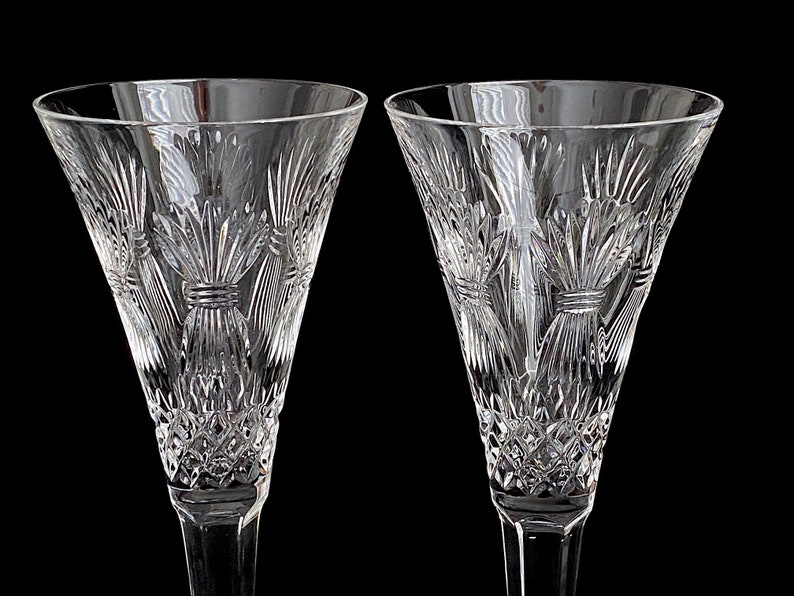 K&ouml;nnte beinhalten: Zwei klare Kristall-Champagnerfl&ouml;ten mit einem geschliffenen Glasdesign. Die Fl&ouml;ten haben einen hohen, schlanken Stiel und eine breite, schalenf&ouml;rmige Oberseite.