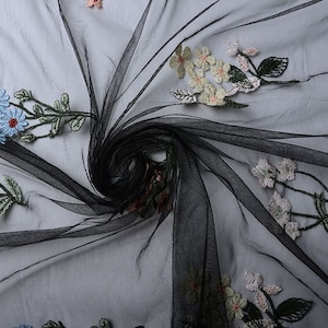 May include: Black sheer fabric with embroidered floral designs in shades of blue, green, white, and pink.