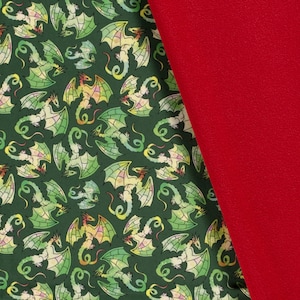 May include: Green fabric with a repeating pattern of stylized dragons in shades of green. The fabric is paired with a solid red fabric.