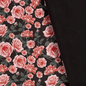 May include: Black fabric with a repeating pattern of pink roses on a black background.