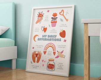 May include: A framed print with the words "MY DAILY AFFIRMATIONS" and various illustrations. The illustrations include a bouquet of flowers, a heart, a key, a strawberry, a rainbow, and a jar of hearts. The print is leaning against a light blue wall.
