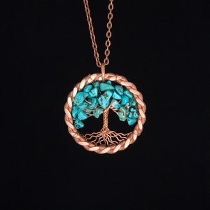 May include: A copper wire tree of life pendant necklace with turquoise stones. The pendant is round and has a detailed wire design.