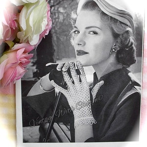 May include: A monochrome vintage photograph of a woman in a hat, earrings, and gloves. The gloves are white, open-weave, and lacy. The image has the text "Vintage With Charm" in cursive.