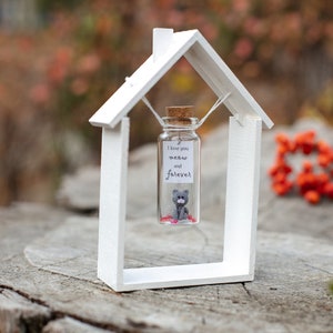 a miniature house with a cat inside of it