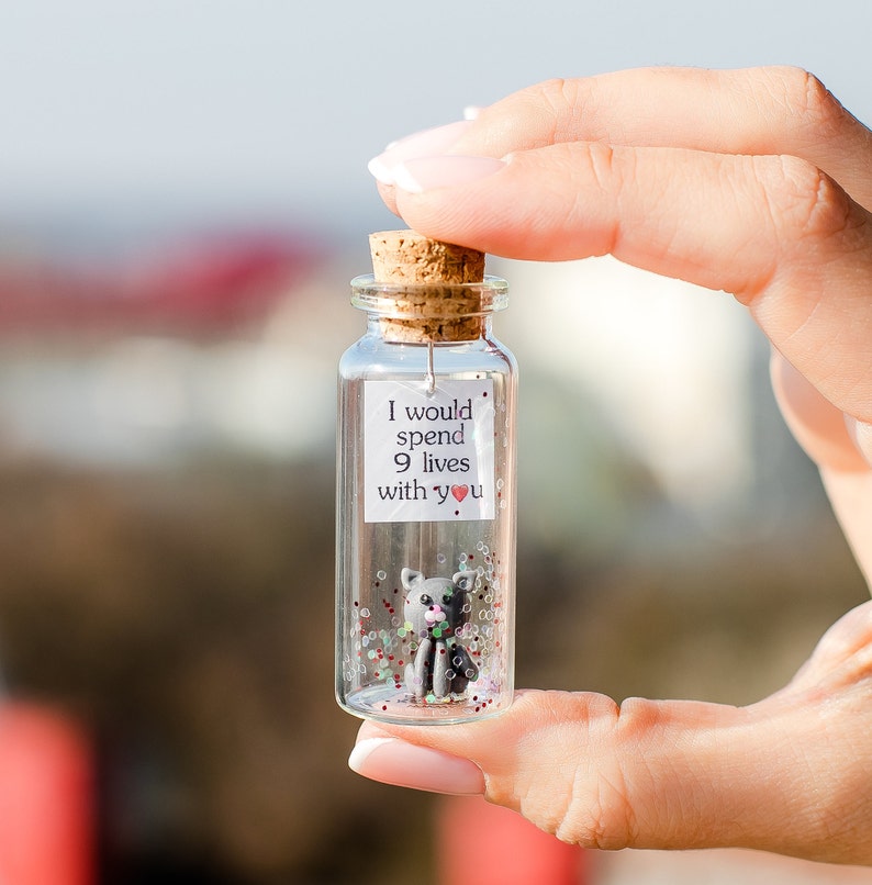 a person holding a tiny bottle with a message on it