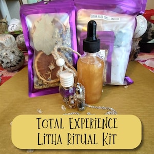 May include: A Total Experience Litha Ritual Kit with a bottle of liquid, small vials, and two purple pouches filled with herbs and dried fruit. The kit includes a bottle with a dropper, a small vial with a silver chain, and a small purple vial.
