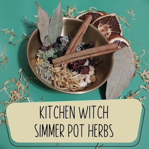 May include: A brass bowl filled with various herbs and spices, including cinnamon sticks, bay leaves, and dried orange slices. The text "KITCHEN WITCH SIMMER POT HERBS" is displayed on a cream-colored banner below the bowl, set against a teal background.