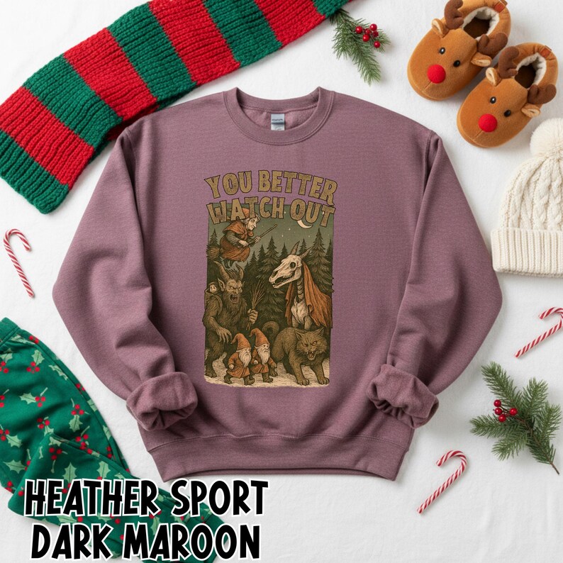 May include: Dark maroon sweatshirt with the text "YOU BETTER WATCH OUT" above a graphic of forest creatures. The sweatshirt is surrounded by holiday-themed items, including a green and red scarf, candy canes, and reindeer slippers.