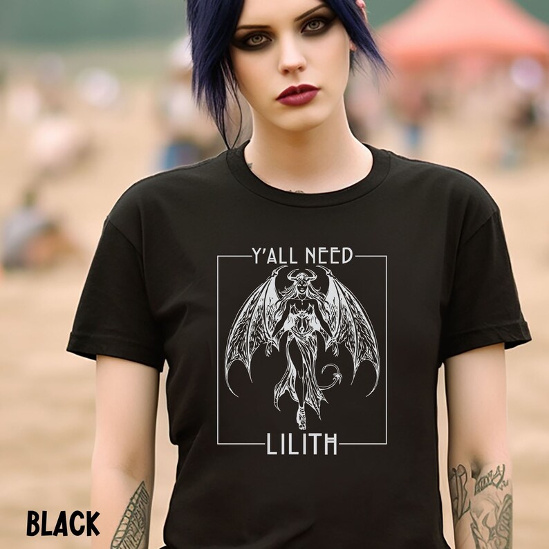 Puede incluir: Camiseta negra con un gr&aacute;fico blanco de una mujer demonio con alas y el texto "Y'all need Lilith."
