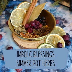 May include: A brass bowl filled with dried herbs, berries, and spices, including cinnamon sticks, bay leaf, and dried lemon slices. The text "IMBOLC BLESSINGS SIMMER POT HERBS" is displayed on a blue background.