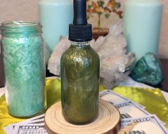 Puede incluir: Una botella de vidrio transparente con un cuentagotas negro, llena de un líquido verde brillante, se encuentra sobre un posavasos de madera. Una vela verde en un tarro y dos velas azul claro están en el fondo. Cristales y moneda estadounidense.