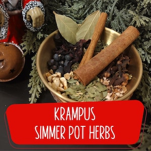May include: A brass bowl filled with various herbs and spices, including cinnamon sticks, bay leaves, and cloves. The text "KRAMPUS SIMMER POT HERBS" is displayed on a red banner below the bowl. The arrangement is set against a backdrop of evergreen branches.