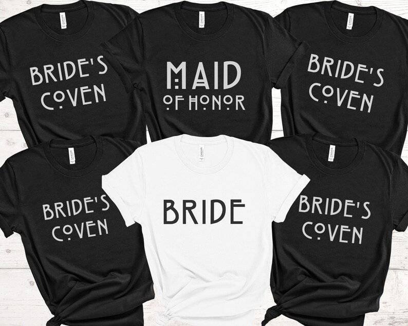 May include: Five black t-shirts with white text. The shirts say "Bride's Coven", "Maid of Honor", and "Bride". One white t-shirt with black text that says "Bride".