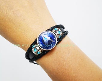 Può includere: Braccialetto in pelle nera con un ciondolo blu e argento con il logo della flotta stellare. Il ciondolo è circondato da piccoli strass blu.