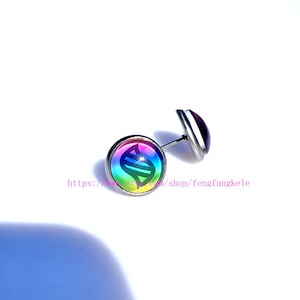 Puede incluir: Un par de pendientes de botón con un diseño colorido con un degradado arcoíris y un engaste de metal plateado. Los pendientes tienen un diseño circular con un símbolo estilizado. El texto "https://www.etsy.com/shop/fengfangkele" es visible.