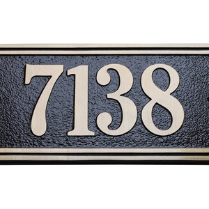 May include: A black and gold rectangular house number plaque with the number 7138 in gold lettering.