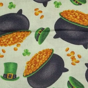 May include: A white fabric with a repeating pattern of black pots filled with gold coins, green shamrock leaves, and green leprechaun hats.