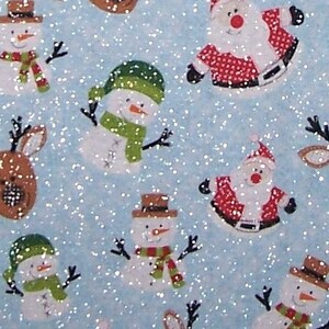 May include: A blue fabric with a glittery texture features a repeating pattern of snowmen, reindeer, and Santa Claus. The snowmen are wearing green hats and scarves, the reindeer are brown, and Santa Claus is wearing a red suit with white trim.