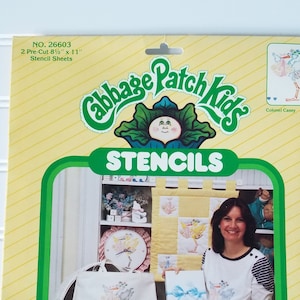 May include: A package of Cabbage Patch Kids stencils. The package is yellow with a green border and features the Cabbage Patch Kids logo and the text "STENCILS". The stencils are 8.5" x 11" and are for home and fashion decor.