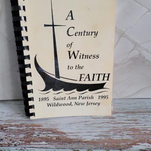 May include: A white ceramic mug with a black handle and the text "But First, Coffee" in a black, handwritten-style font. The mug is on a white surface.