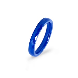 Könnte beinhalten: Ein blauer Keramikring mit geometrischem Muster. Der Ring ist glatt und glänzend.