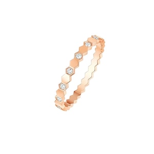 Puede incluir: Anillo de oro rosa con un diseño hexagonal repetido. Cada hexágono está adornado con una pequeña gema transparente. El anillo tiene un diseño delicado y moderno, adecuado para el uso diario o ocasiones especiales. El anillo mide aproximadamente 1,5 mm de ancho.
