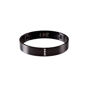 May include: A black stainless steel bangle bracelet with a row of clear cubic zirconia stones. The bracelet has a brushed finish and the words "b.till" are engraved on the inside.