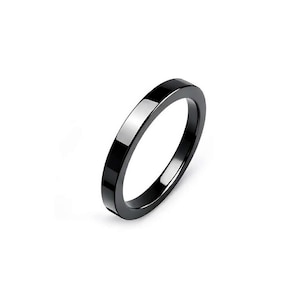 May include: A sleek, black ring with a flat, rectangular band. The ring has a polished, reflective surface, creating a minimalist and modern aesthetic. The ring is a simple, yet elegant piece of jewelry.