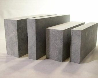 Puede incluir: Cuatro bloques rectangulares de hormigón gris, dispuestos en orden decreciente de tamaño de izquierda a derecha.