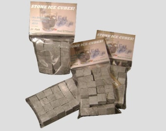Puede incluir: Tres paquetes de cubitos de hielo de piedra gris. Cada paquete tiene una etiqueta que dice "Stone Ice Cubes!" y muestra un vaso de agua con hielo. La etiqueta también dice "24-Pack".