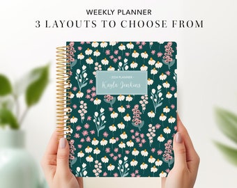 May include: A teal blue weekly planner with a floral pattern featuring white flowers, pink and yellow accents. The planner has a gold coil binding and a personalized name label that reads "Kayla Jenkins".