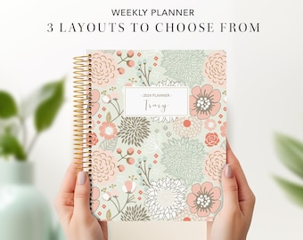 May include: A weekly planner with a floral design in shades of pink, green, and gray. The planner has a gold spiral binding and the text "2024 Planner - Tracy" on the front cover.