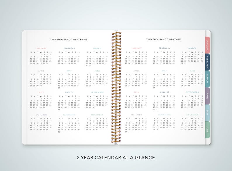 May include: A two-year calendar at a glance, with monthly pages for 2025 and 2026. The calendar is bound with a gold spiral and has colorful tabs for each month.
