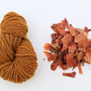 Könnte beinhalten: Eine Kugel braunes Garn und ein Haufen getrockneter Zwiebelschalen, beides zum Naturfärben.