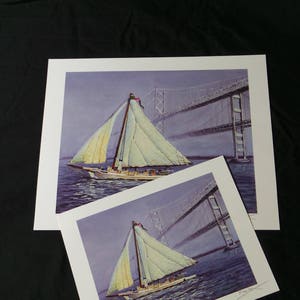 May include: A painting of a sailboat with white sails, sailing under a bridge. The bridge is a suspension bridge with a gray metal structure. The water is a light blue color. The painting is signed by the artist.