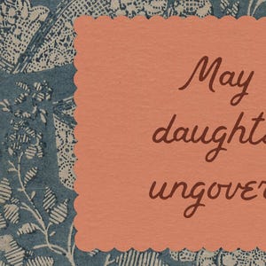 May include: A peach-colored card with scalloped edges, featuring handwritten brown text. The card is set against a backdrop of blue and white floral patterned paper. The text on the card reads "May daughters uncover".