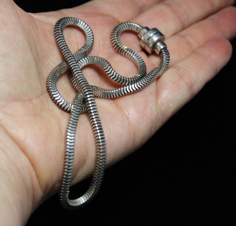 May include: A silver snake chain necklace with a magnetic clasp.
