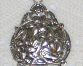 Piękny ażurowy duży wirujący naszyjnik z zawieszką w kształcie kwiatu lilii w kolorze srebrnym