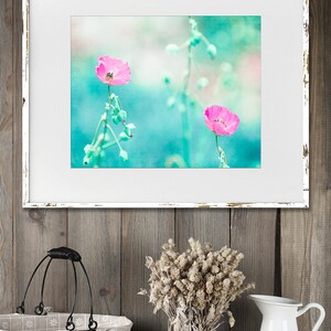 May include: A framed print of two pink flowers with green stems against a turquoise background. The frame is white with a distressed look.