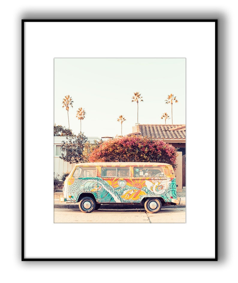May include: A yellow vintage van with colorful psychedelic artwork, including waves, a sun, and peace signs, parked on a street with palm trees in the background.