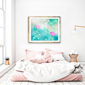 May include: A framed print of two pink flowers with green stems against a turquoise background.